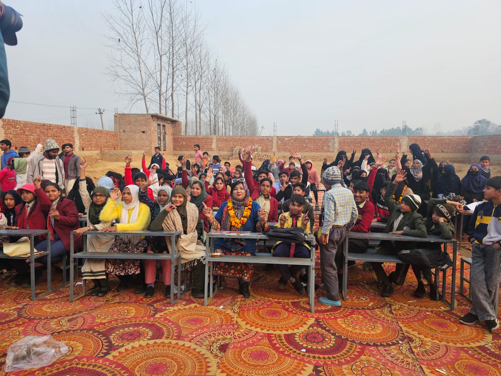 Advocate Shahjabeen Qazi seated among dozens of cheerful school students