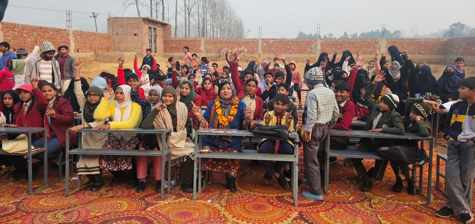 Wide angle view of open-air community student assembly and encouragement drive