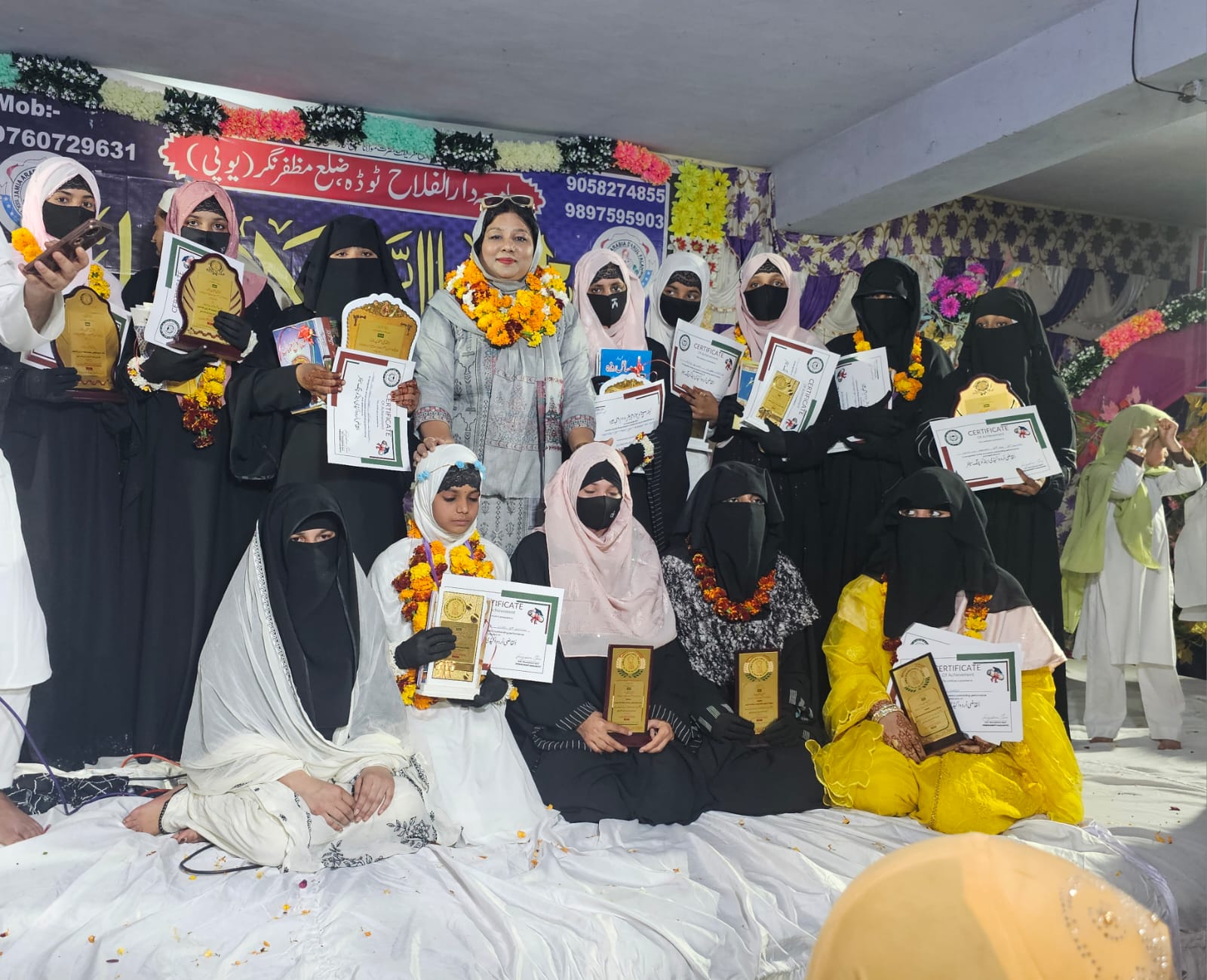 Stage felicitation with students presenting plaques and certificates