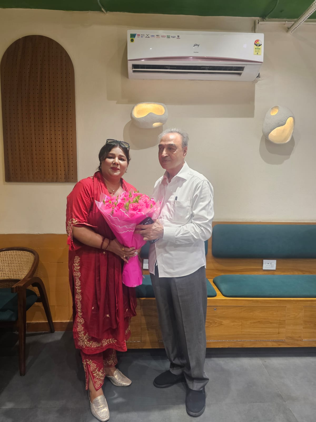 Felicitating senior academic advisor with ceremonial floral bouquet