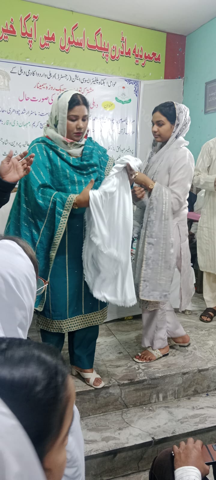Draping ceremonial honor shawls upon meritorious students